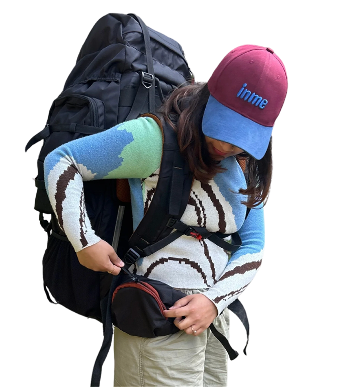 Person wearing INME hiking gear and backpack